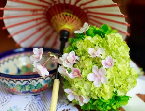 A vibrant display featuring a green hydrangea bouquet, delicate pink blossoms, and a traditional Japanese umbrella in the background, perfect for wedding flower photos.