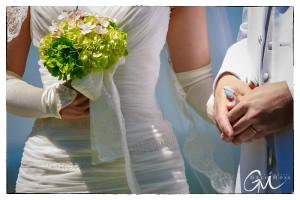 Close-up of a bride and groom at Salem Cross Inn, focusing on their hands clasped together and the bride's bouquet of green and white flowers.