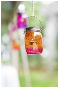 A colorful glass jar hanging by a string with a blurred green background at Crissey Farms Great Barrington.