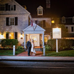 A couple walks hand in hand in front of the lit entrance to the Lord Jeffery Inn at night, a popular venue for weddings.