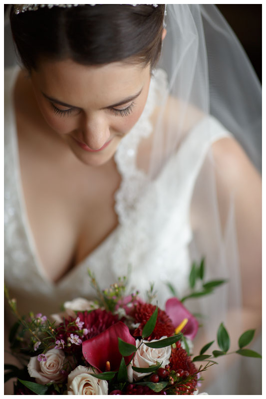 Wedding day bridal portrait with bride looking down at flower bouquet