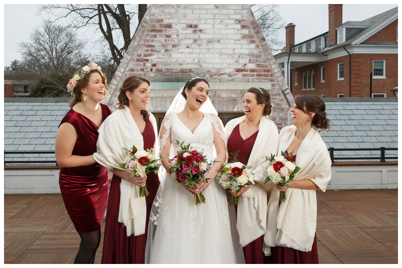 Bride and Bridesmaids laughing on the upper deck in front of the fireplace at the Inn on Boltwood