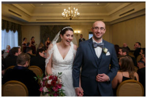 Bride and Groom walkin down the aisle in the ballroom at the inn on Boltwood