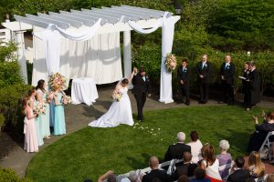 Bride and groom holding hands up in the air during recessional