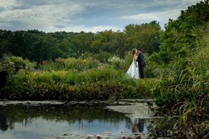 Bride and Groom in garden with reflection in pond