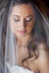 Gorgeous portrait of bride on wedding day with amazing makeup shot through veil.