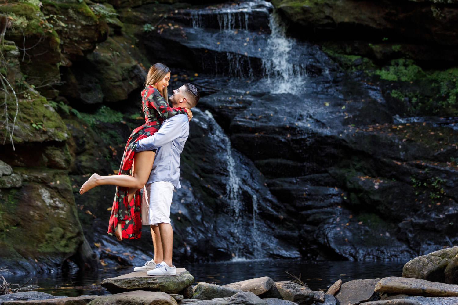 Gorgeous engaged couple with waterfall behind them