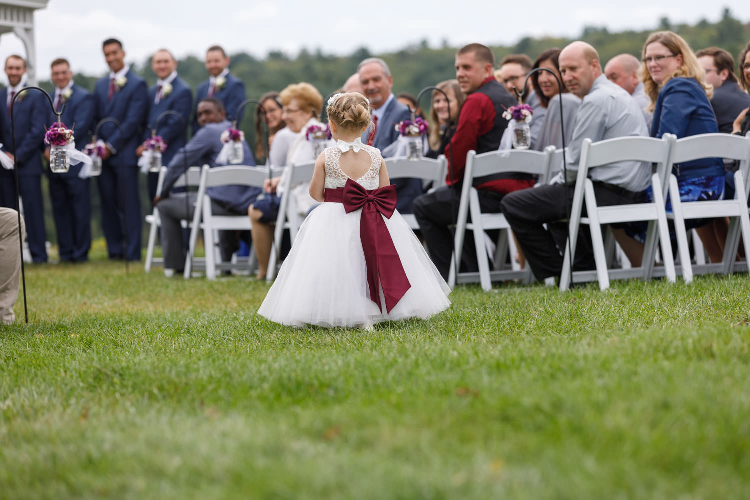 Flower girl walking down the aisle at outdoor ceremony