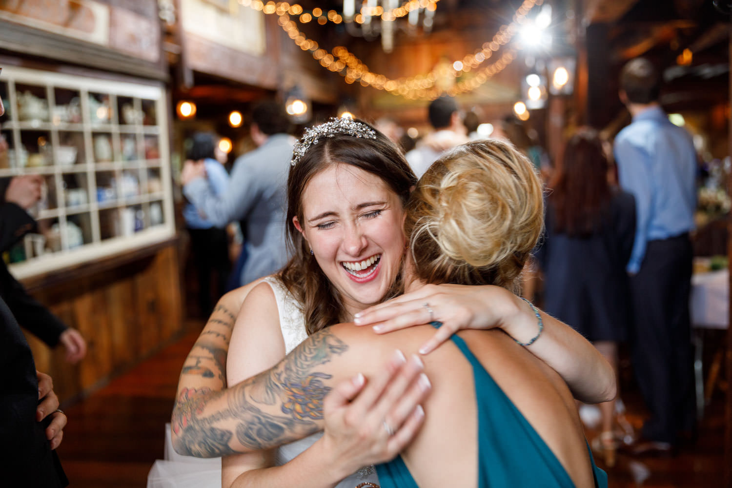 Happy bride hugging sister in law during wedding reception
