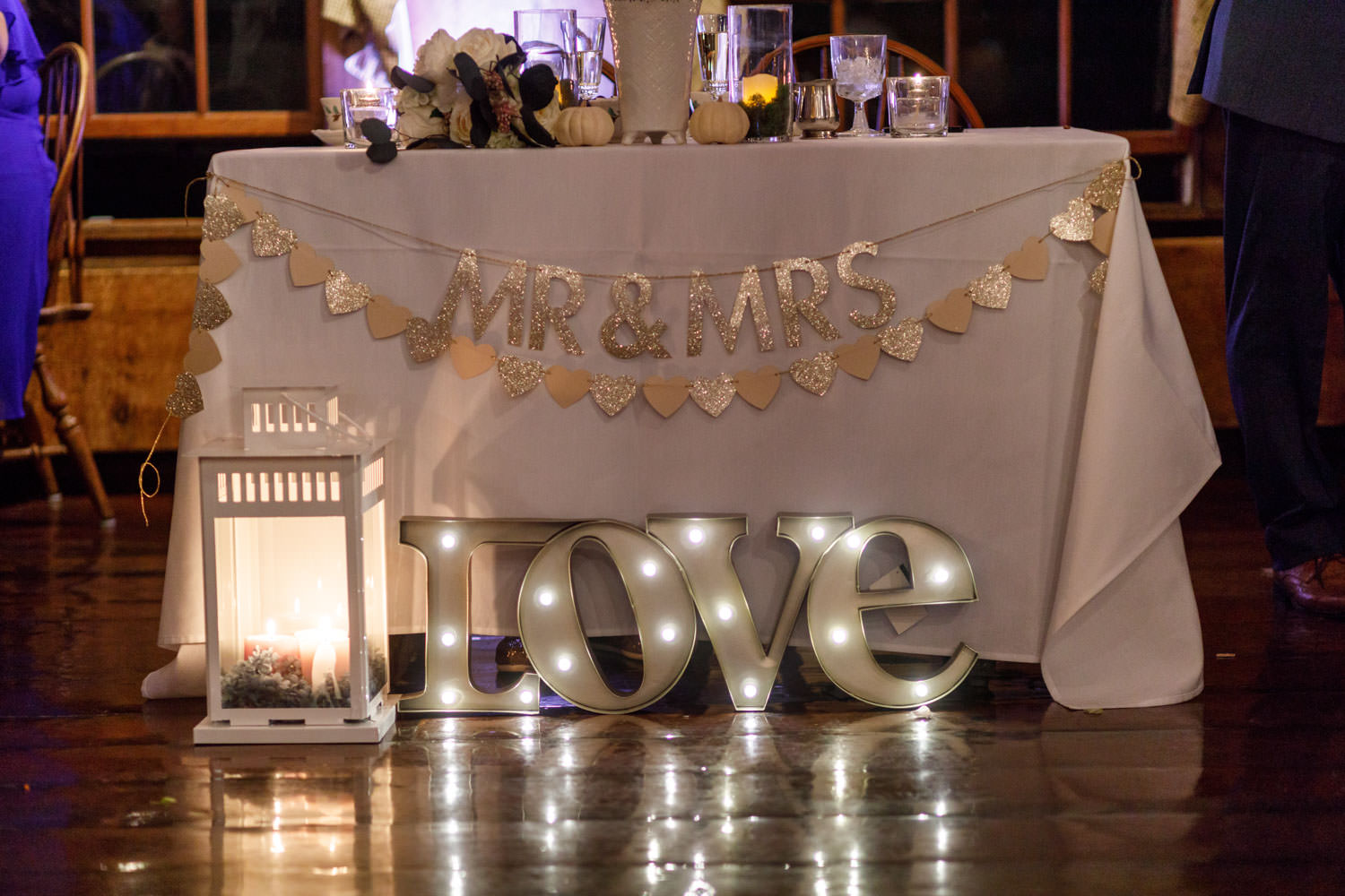 Sweetheart table with Love sign in the foreground.
