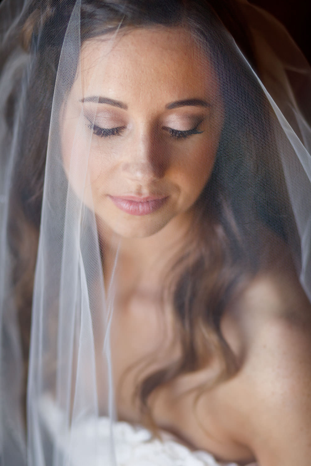 Beautiful wedding day portrait with the brides eyes closed. Shooting through the veil giving a soft look to her portrait.