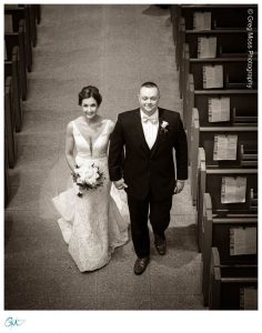 Black and White photo of Bride and Groom walking down the aisle