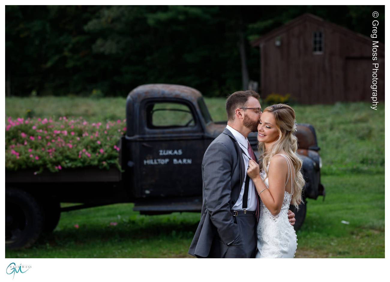 Zukas HIlltop Barn Truck with flowers and Groom Kissing bride in front