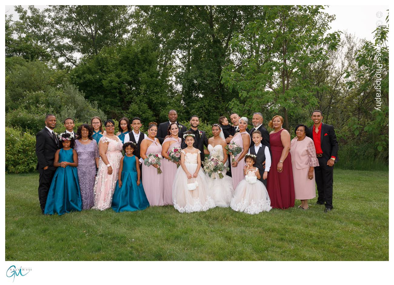 Large family photo at wedding in grassy area