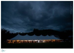 Lit up tent at night with dramatic clouds
