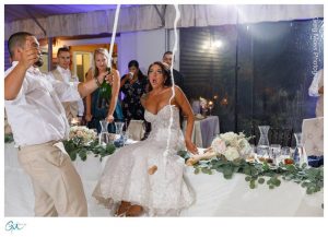 Groom popping champagne in front of bride with surprised expression