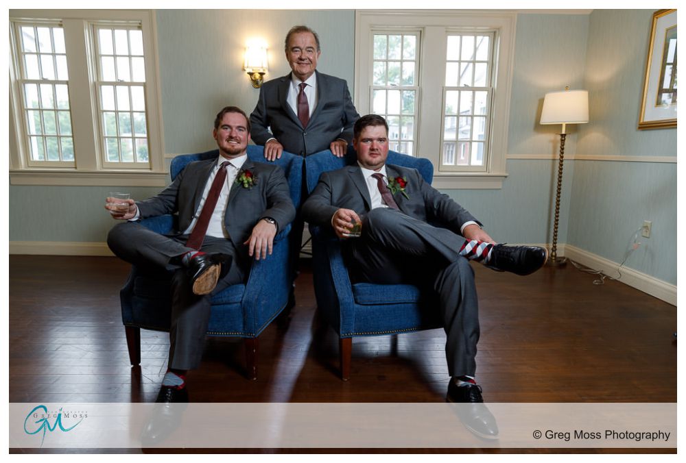 Father of the groom, brother and groom in chairs with rocks glasses