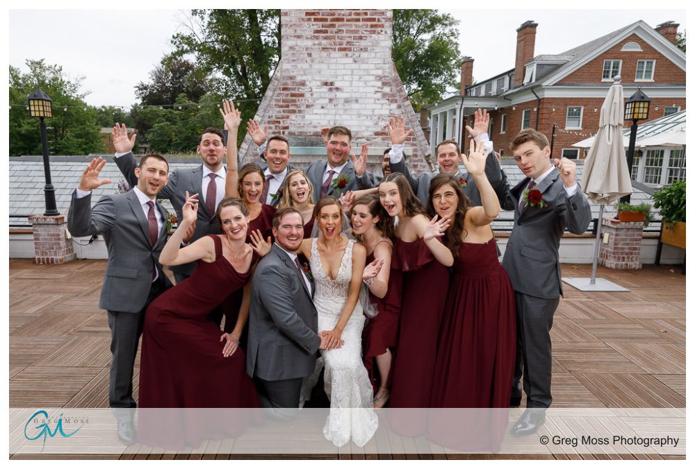 Complete wedding party throwing arms up in the air