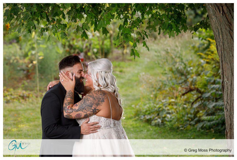 Bride and Groom kissing under a tree