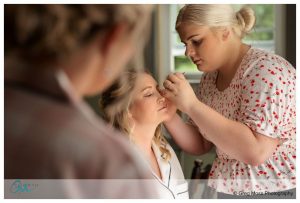 Bride getting makeup done before wedding