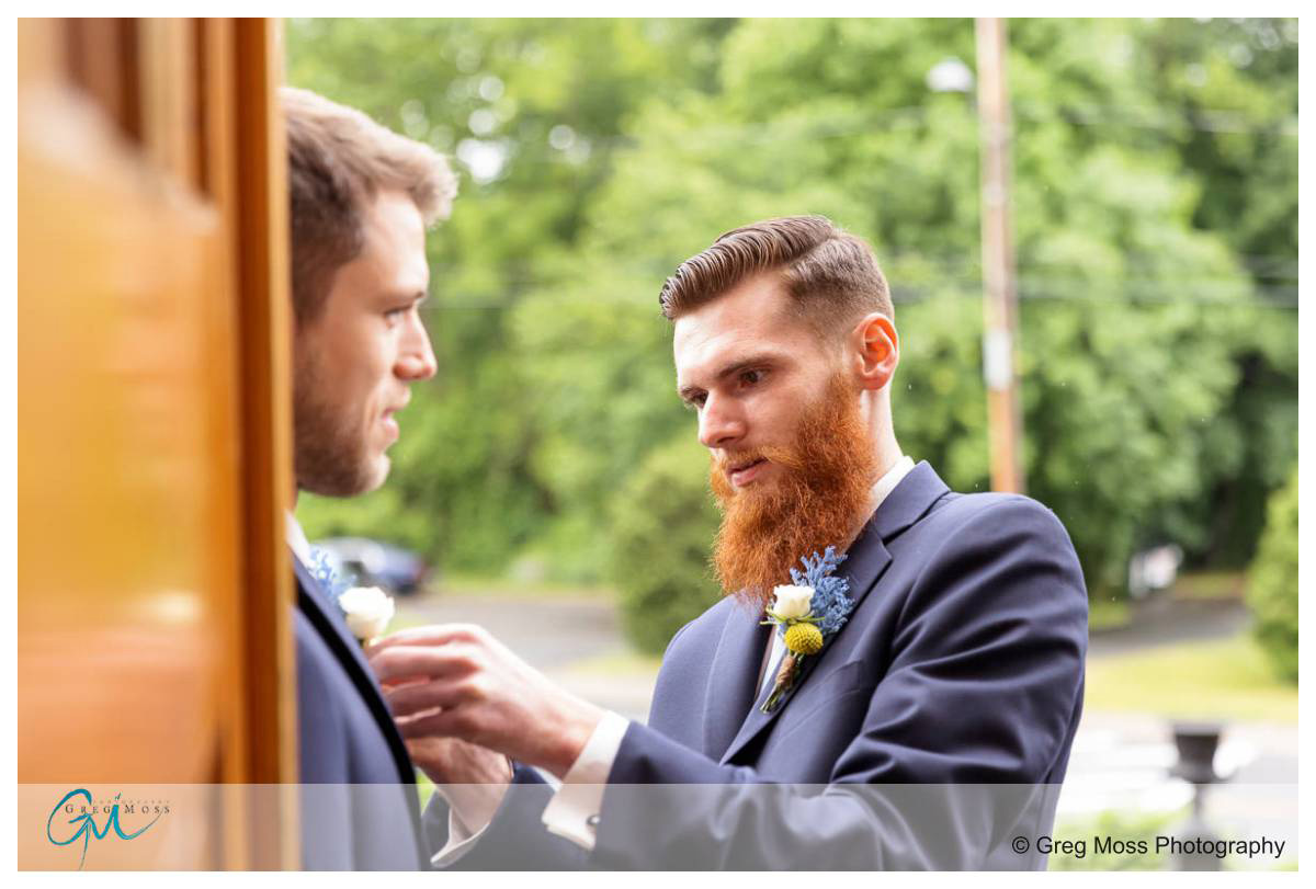 Groomsmen helping groomsmen with tie