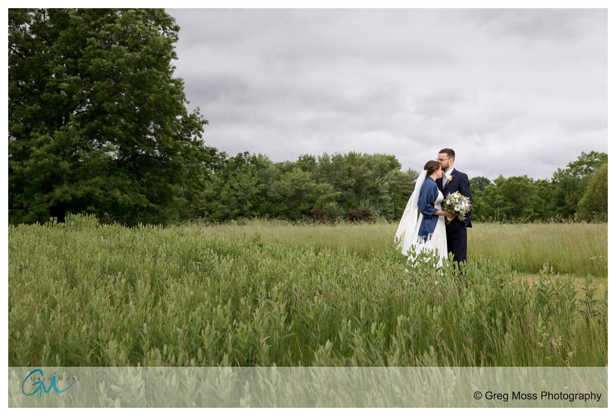 Wedding couple in the field at Hampshire college and Red Barn