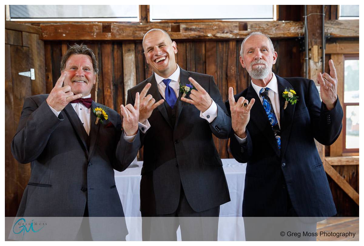 Groom with both fathers inside the red barn at Hampshireddd college