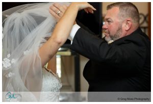 Dad pulling veil over bride before she walks down the aisle.