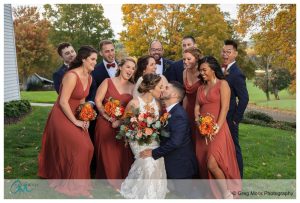 full wedding party photo with fall foliage in background