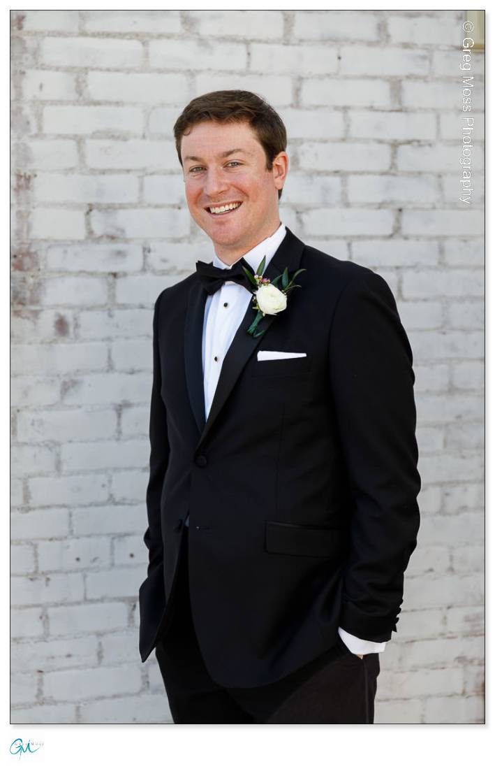 Groom Portrait in front of white brick wall