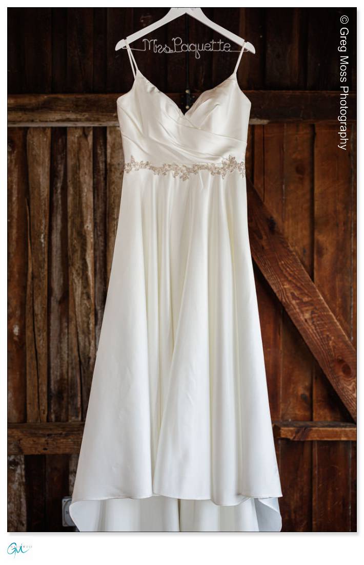 Brides wedding dress hanging in the Red Barn