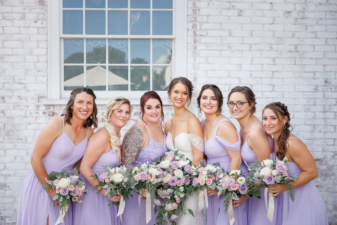 Bridal party with white brick wall behind them
