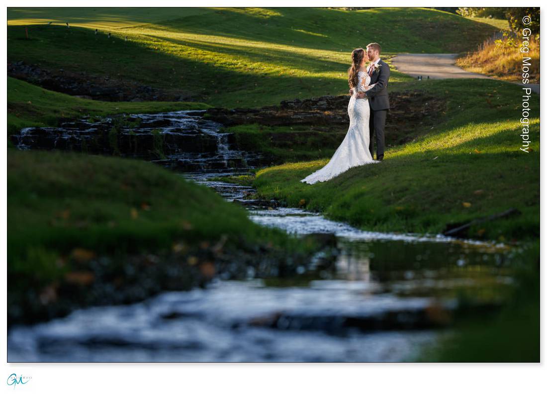 Wedding couple portrait with creek in foreground on the golf course