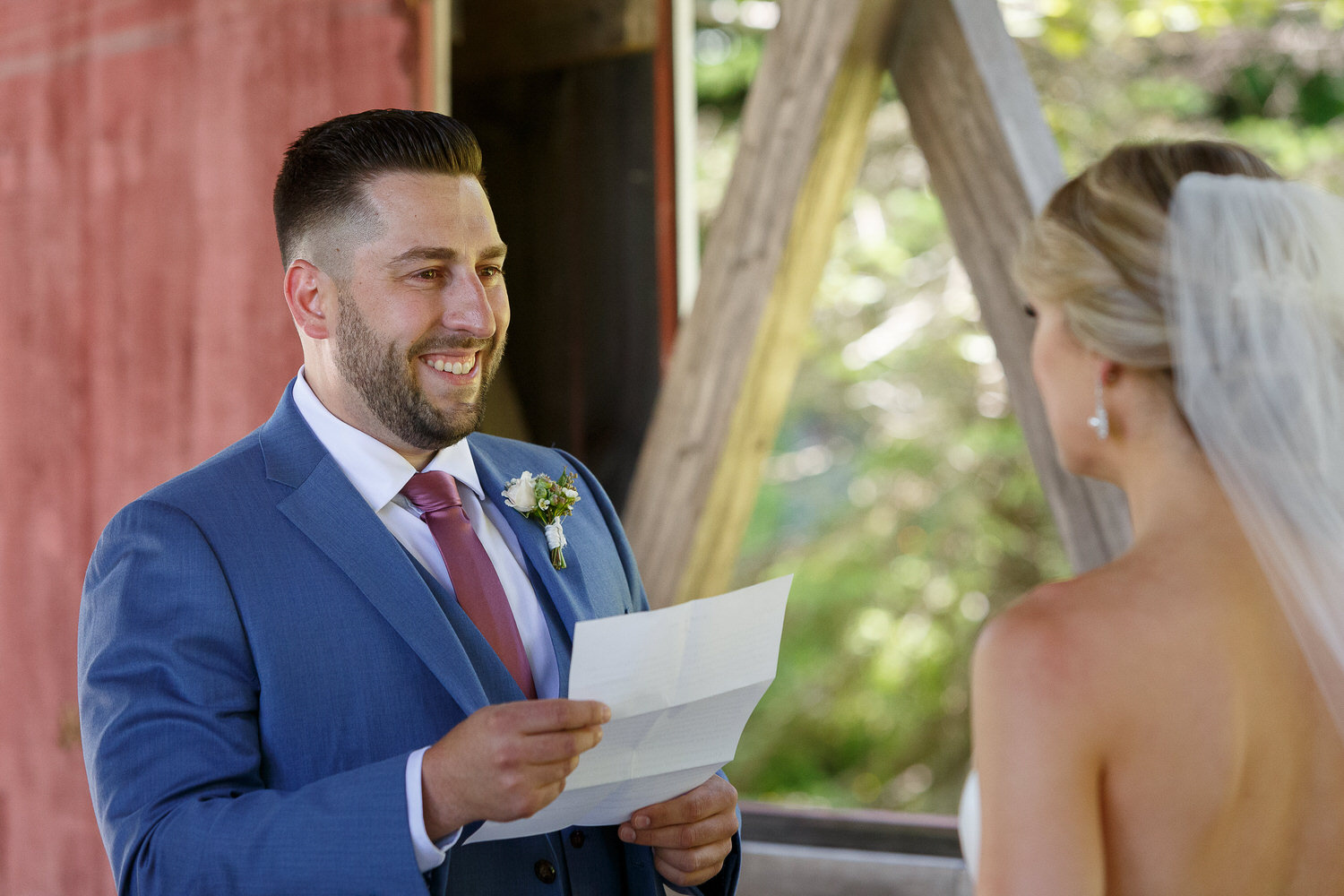 Groom reading letter to bride during first look